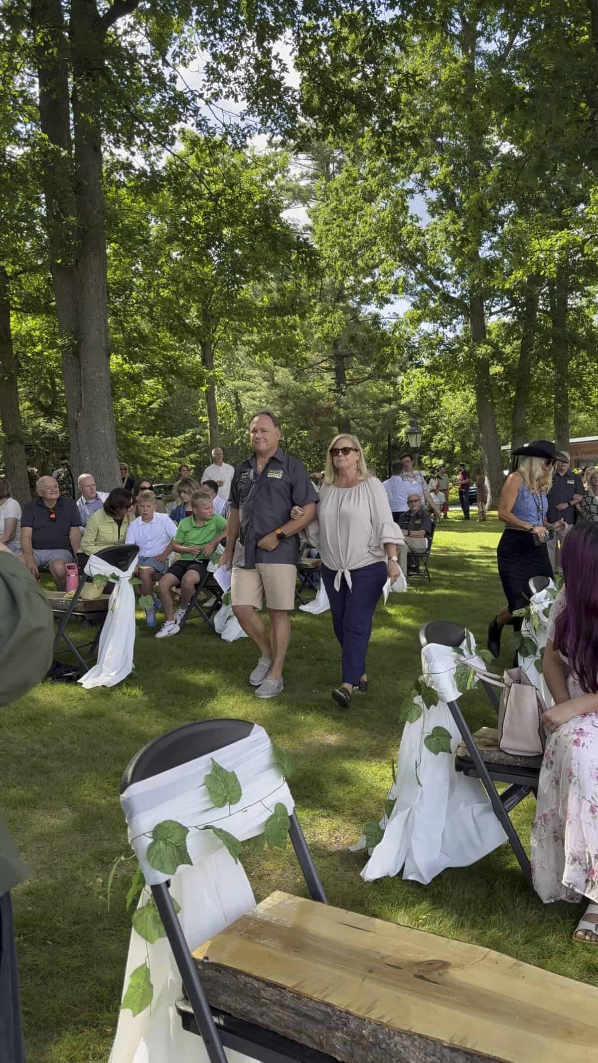People enjoying outdoor event at Camp Happily Ever After in a wooded area.