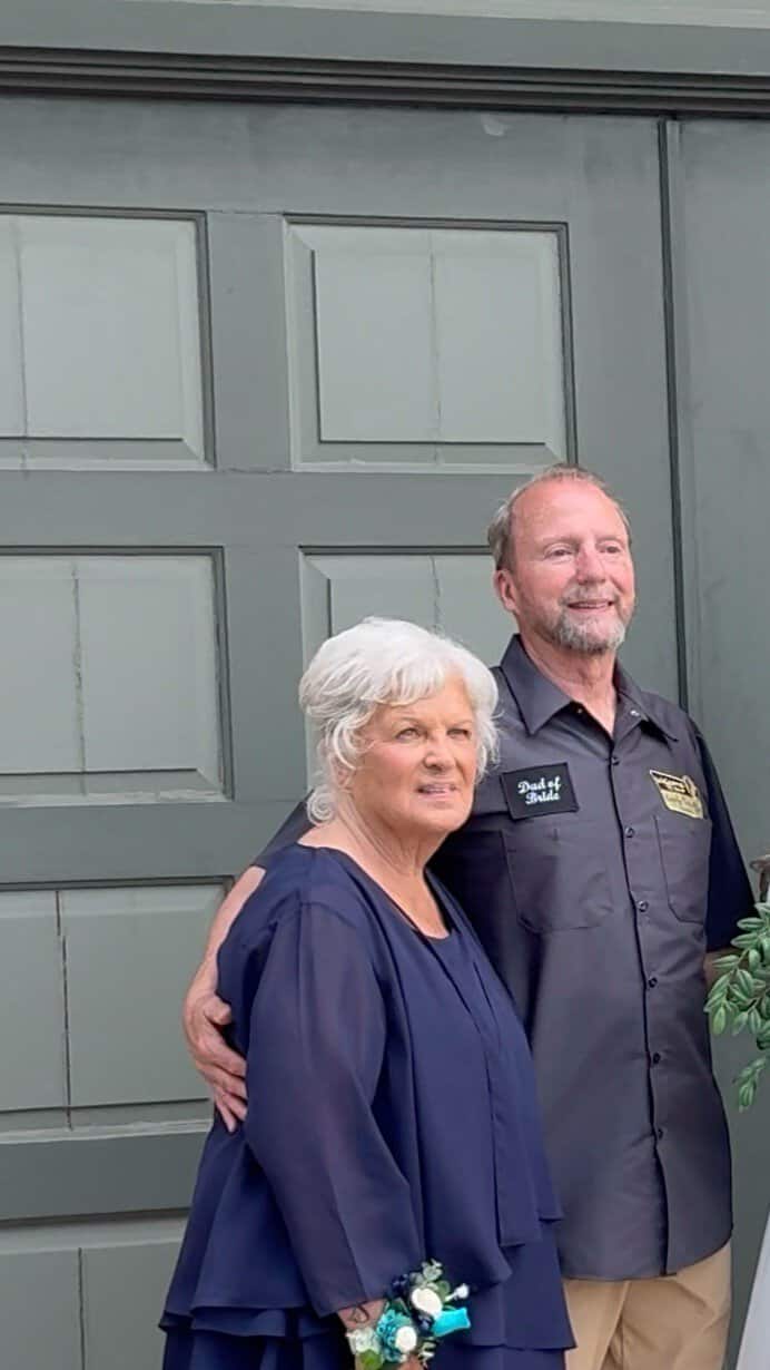 Camp Happily Ever After staff member with elderly woman in front of gray door.